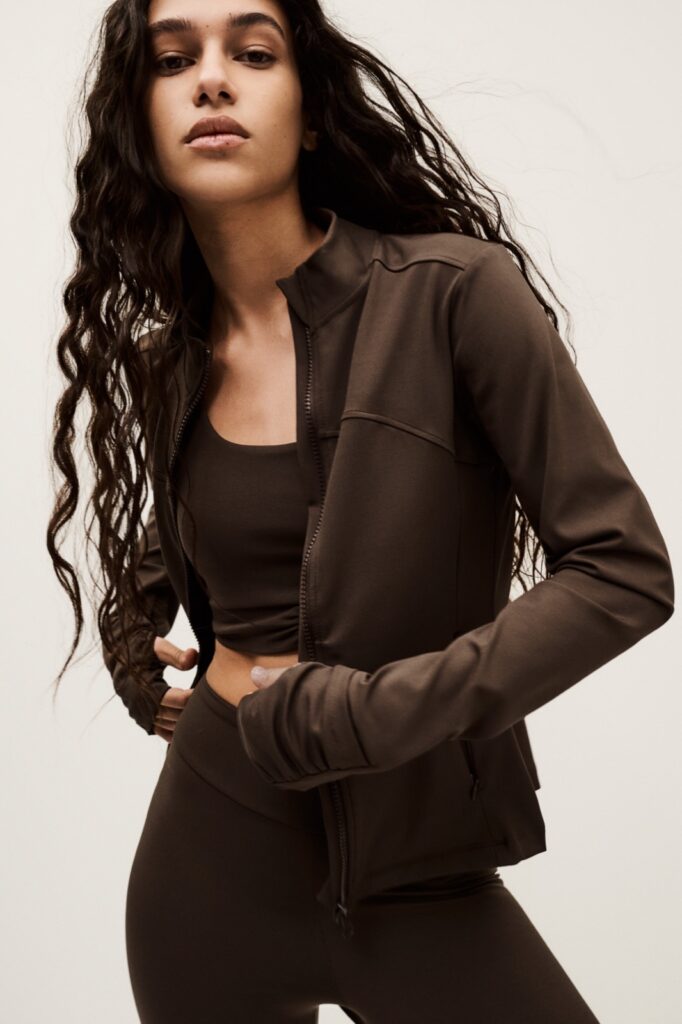 Veste zippée Gladys de ba&sh en jersey ébène, col montant, portée avec un legging assorti