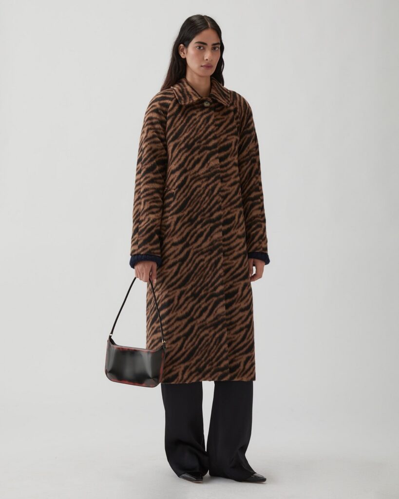 Manteau Alice de Rejina Pyo, long jacquard tigré beige et noir en laine mélangée, porté ouvert sur un pantalon noir large