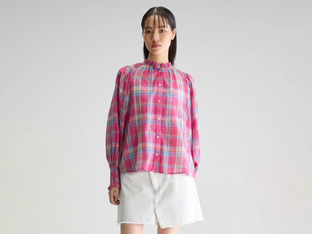Blouse Cassis de Bellerose en voile de coton à carreaux rose, col froncé et manches longues, portée avec une jupe en jean clair