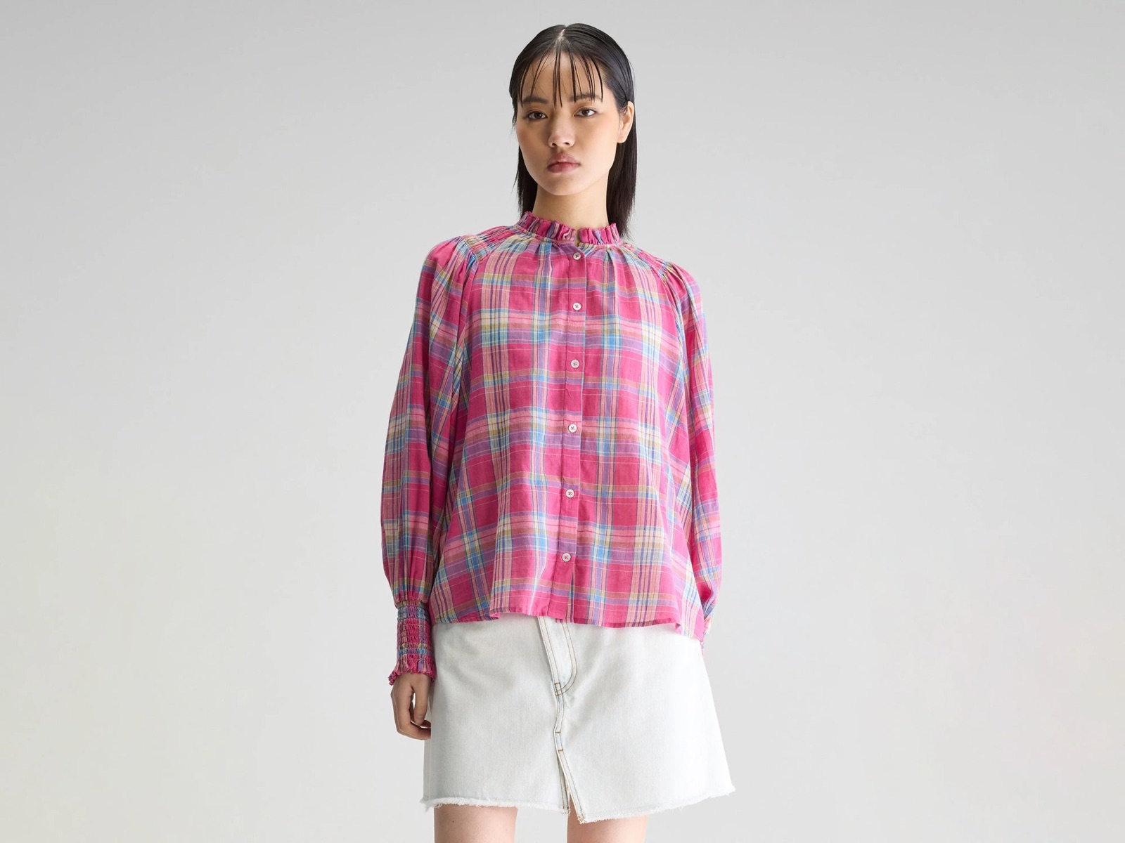 Blouse Cassis de Bellerose en voile de coton à carreaux rose, col froncé et manches longues, portée avec une jupe en jean clair