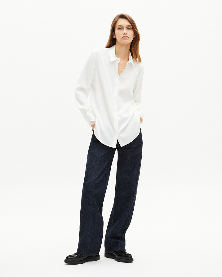 Chemise en soie écrue The Kooples, coupe droite col classique, portée avec un jean large indigo et des mocassins noirs