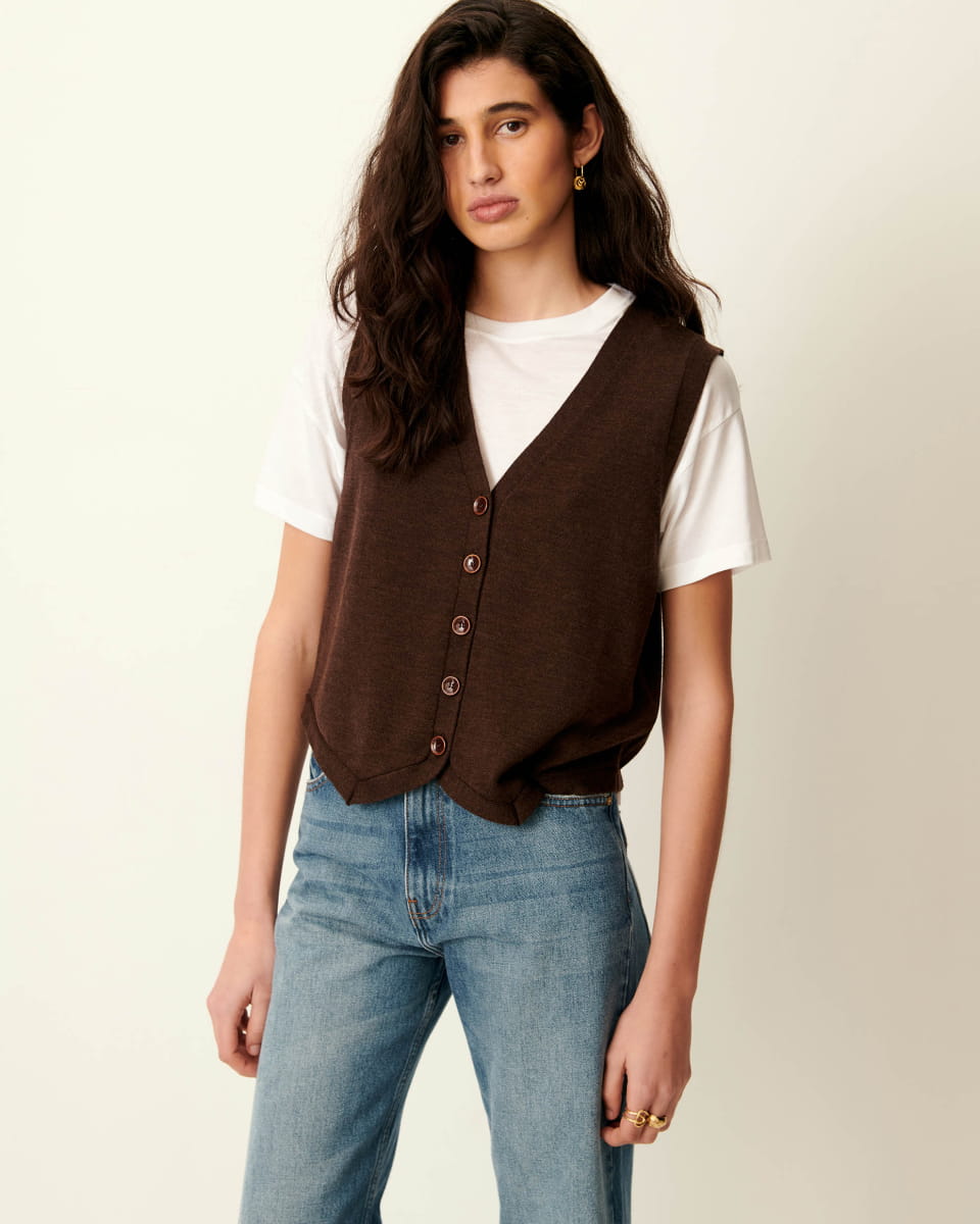 Gilet sans manches Giancarlo de Sessun en maille merinos brun cafe, col en V et boutonnage, porte sur un tee-shirt blanc et un jean