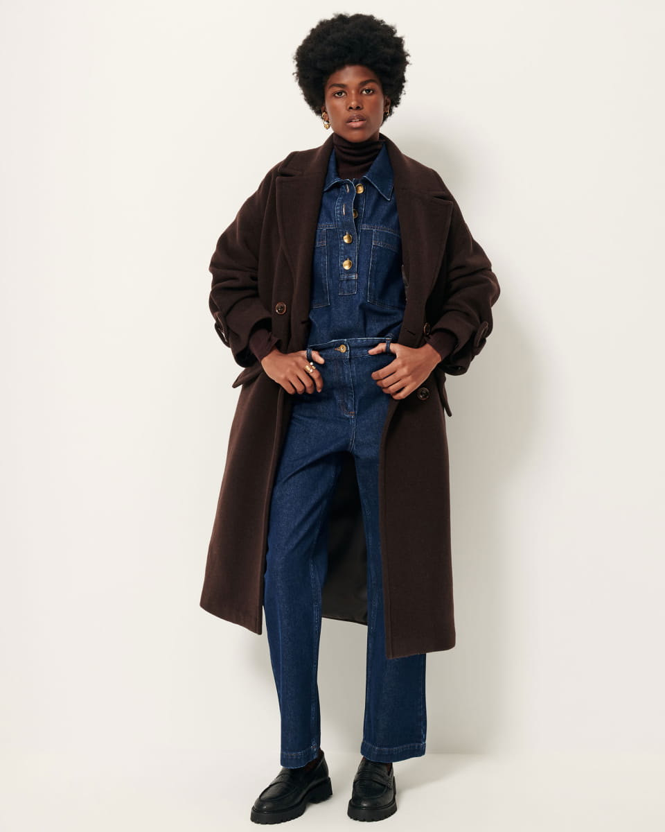 Manteau long Mia de Sessùn en laine melton brun café, porté ouvert sur une salopette en jean