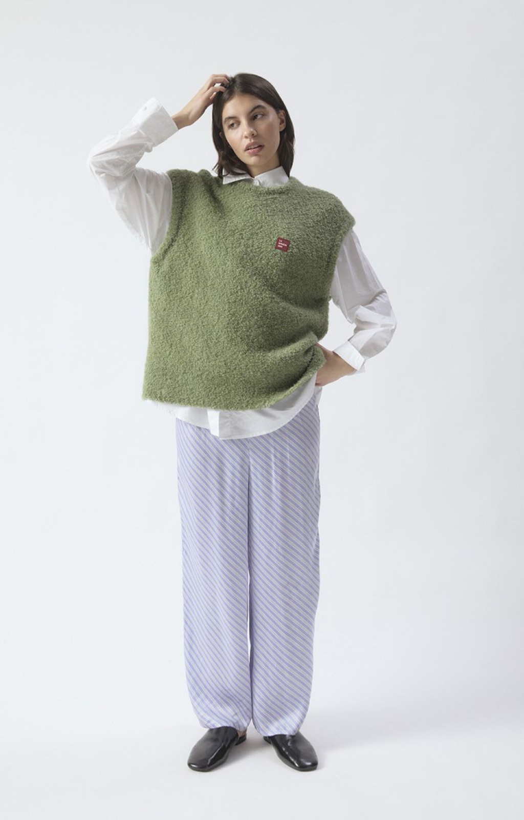 Pull sans manches Zolly d'American Vintage en maille bouclée vert amande, porté sur une chemise blanche