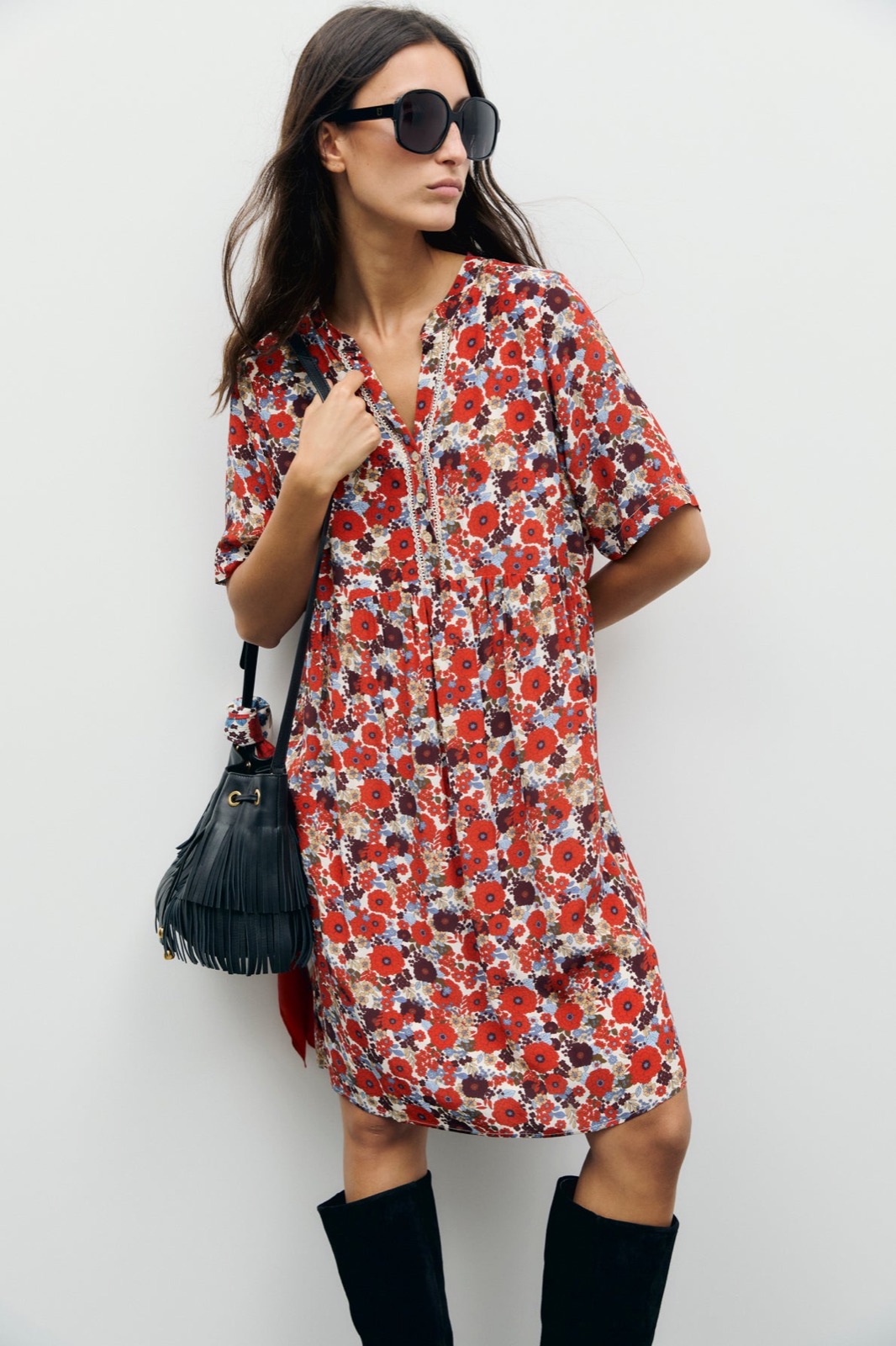 Robe courte fleurie Colle de Gérard Darel, imprimé floral rouge et bordeaux, portée avec des bottes hautes noires