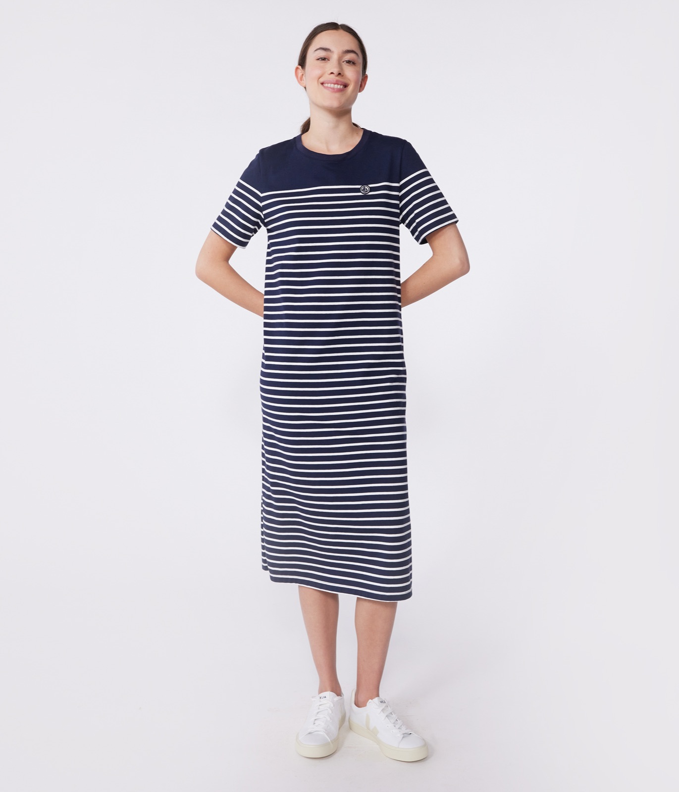 Robe midi en jersey de coton à rayures bleu marine et blanc Petit Bateau, badge marin brodé, portée avec des baskets blanches