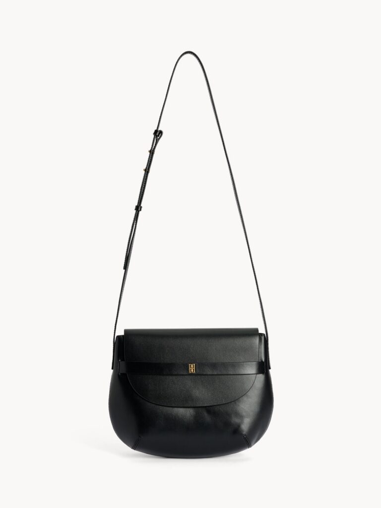 Sac Maellon en cuir noir de By Malene Birger, silhouette arrondie, bandouliere ajustable et monogramme dore