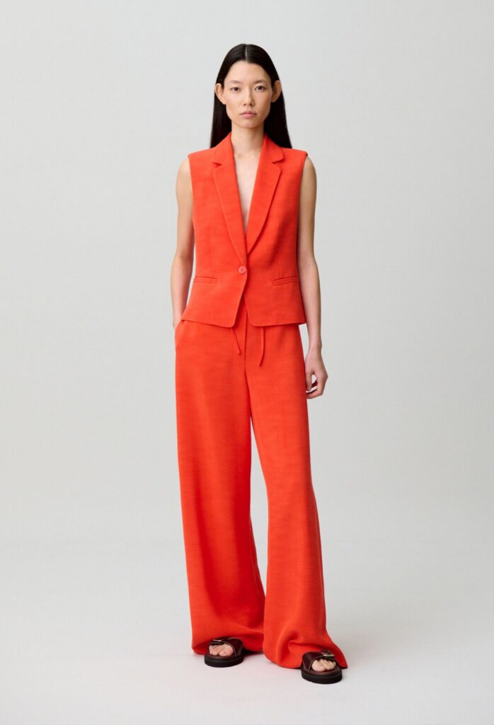 Gilet de tailleur sans manches corail Claudie Pierlot, porté avec un pantalon large assorti