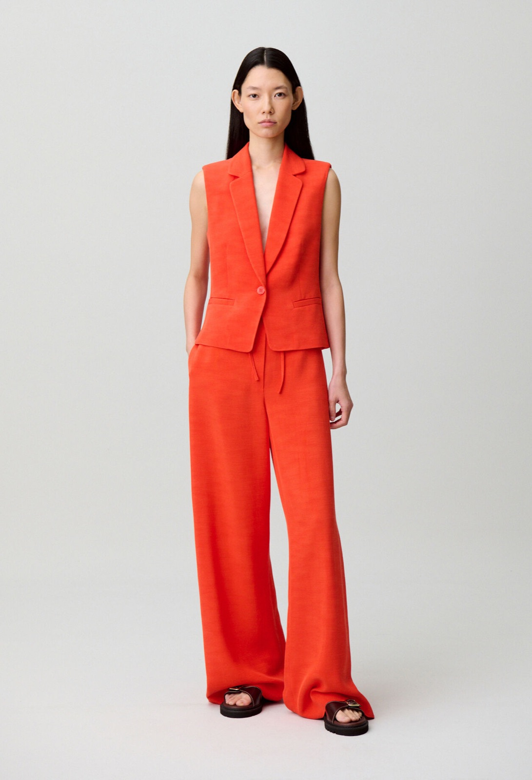 Gilet de tailleur sans manches corail Claudie Pierlot, porté avec un pantalon large assorti