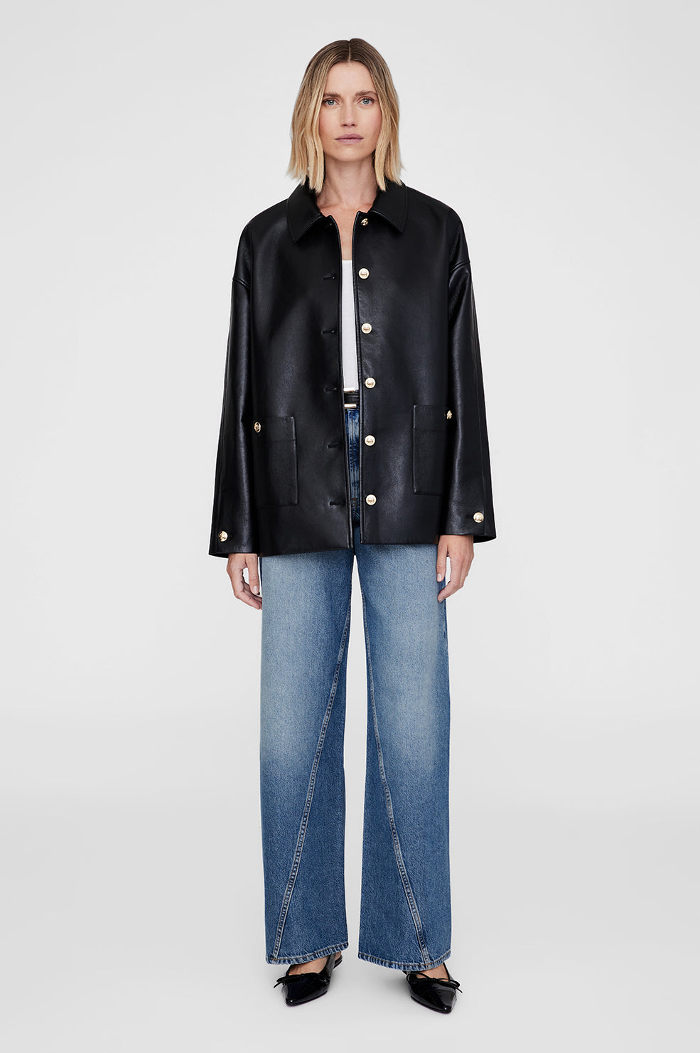 Veste Luca d'Anine Bing en cuir noir recycle, boutons dores, coupe oversize portee sur un tee-shirt blanc et un jean large