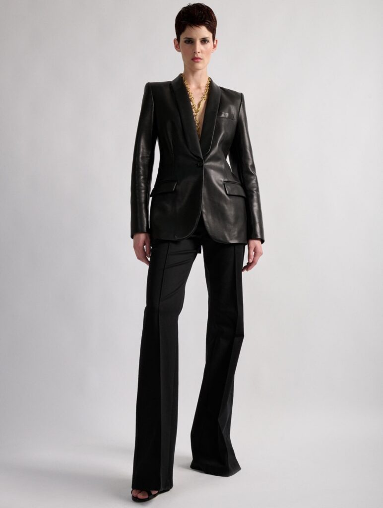 Veste blazer col châle cintrée en cuir d'agneau plongé noir Barbara Bui, portée avec un pantalon de costume noir