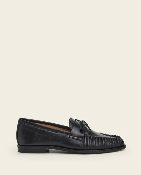 Mocassin Dylan de Flattered en cuir noir avec bride nouée sur le dessus, semelle plate