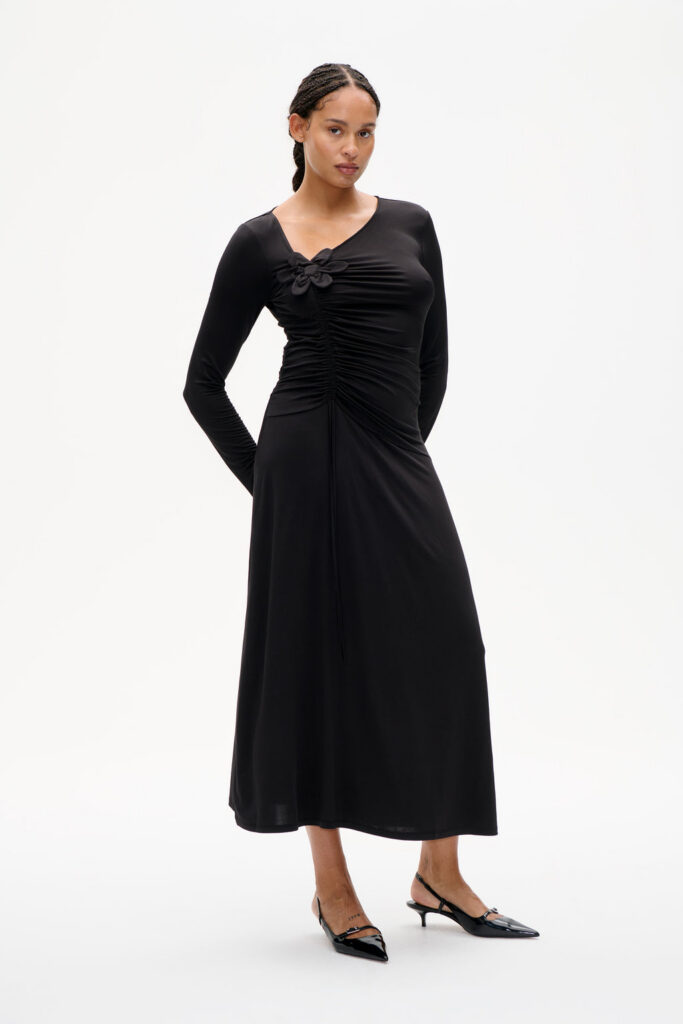Robe longue noire Josina de Baum und Pferdgarten, fronces au buste et fleur en tissu, portée avec des slingbacks vernies
