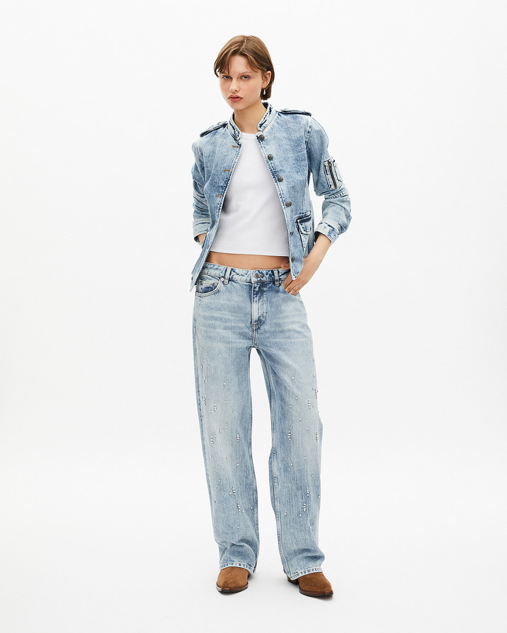 Veste style officier en denim délavé The Kooples, portée ouverte sur un tee-shirt blanc et un jean large