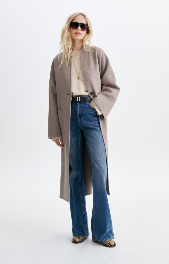 Manteau Bachir taupe de Vanessa Bruno, coupe oversize mi-longue en laine double face, porté ouvert sur un pull crème et un jean flare