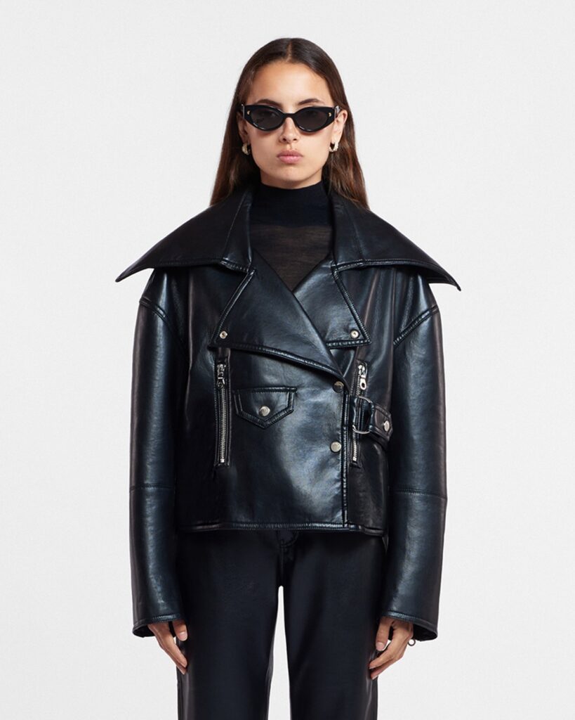 Veste biker Ado de Nanushka en cuir régénéré noir, col châle surdimensionné, portée sur un col roulé noir