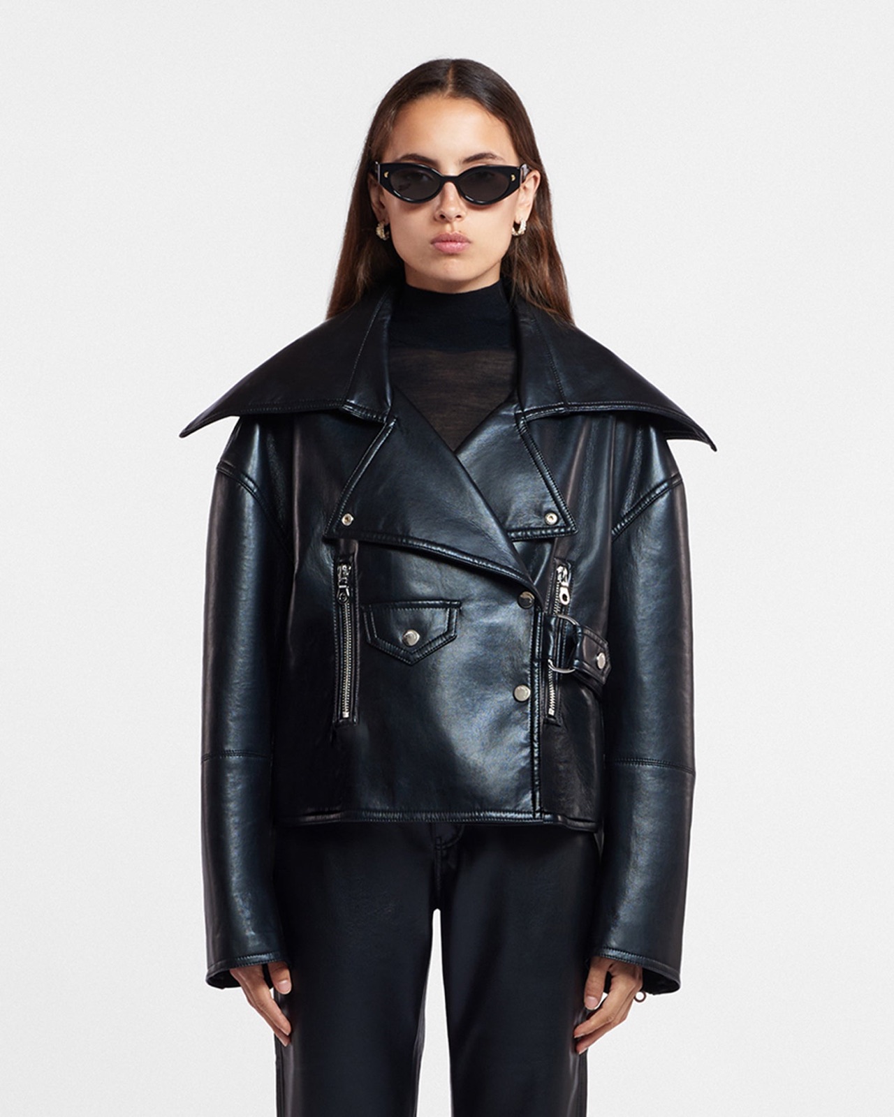Veste biker Ado de Nanushka en cuir régénéré noir, col châle surdimensionné, portée sur un col roulé noir