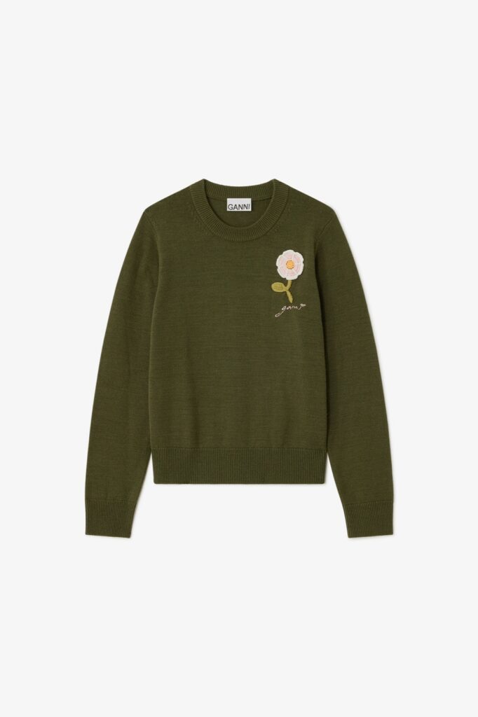 Pull en laine vert kaki de Ganni orné d'une fleur au crochet rose sur le devant