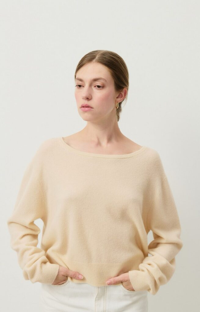 Pull Raxow American Vintage en maille crème, col bateau et coupe boule, porté avec une jupe en jean écrue