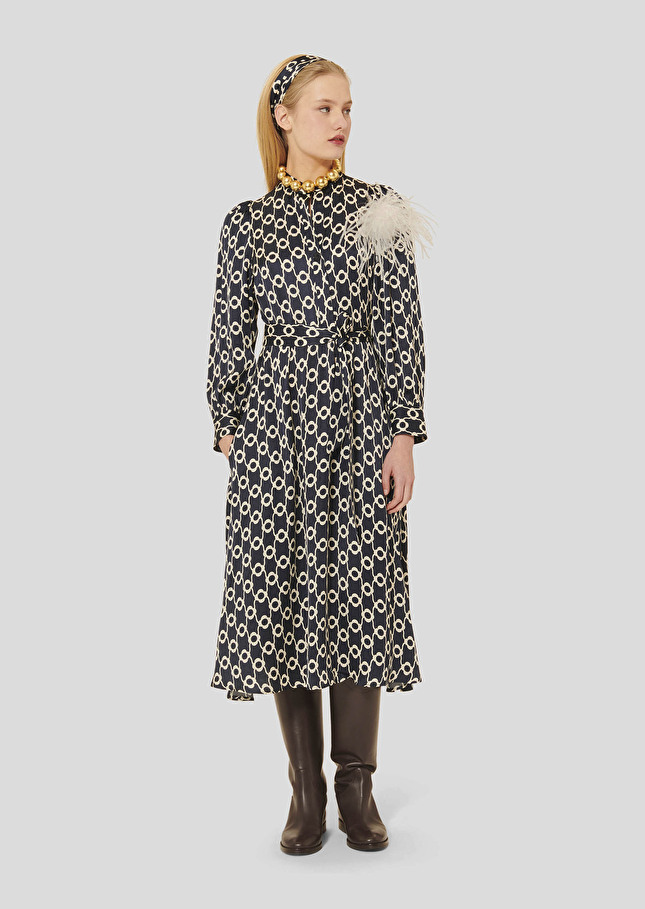 Robe Rivoltina de Tara Jarmon, robe mi-longue bleu nuit à motif écru, manches longues bouffantes, portée avec des bottes en cuir marron