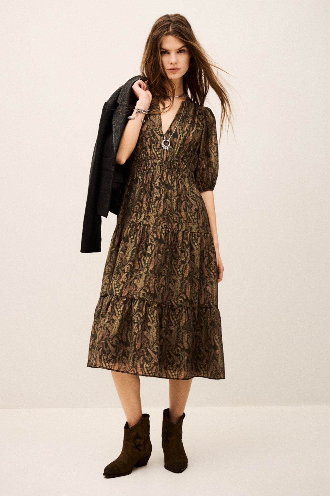 Robe midi Tanyssa de ba&sh, imprimé cachemire kaki, manches bouffantes et jupon à étages, portée avec des santiags en daim