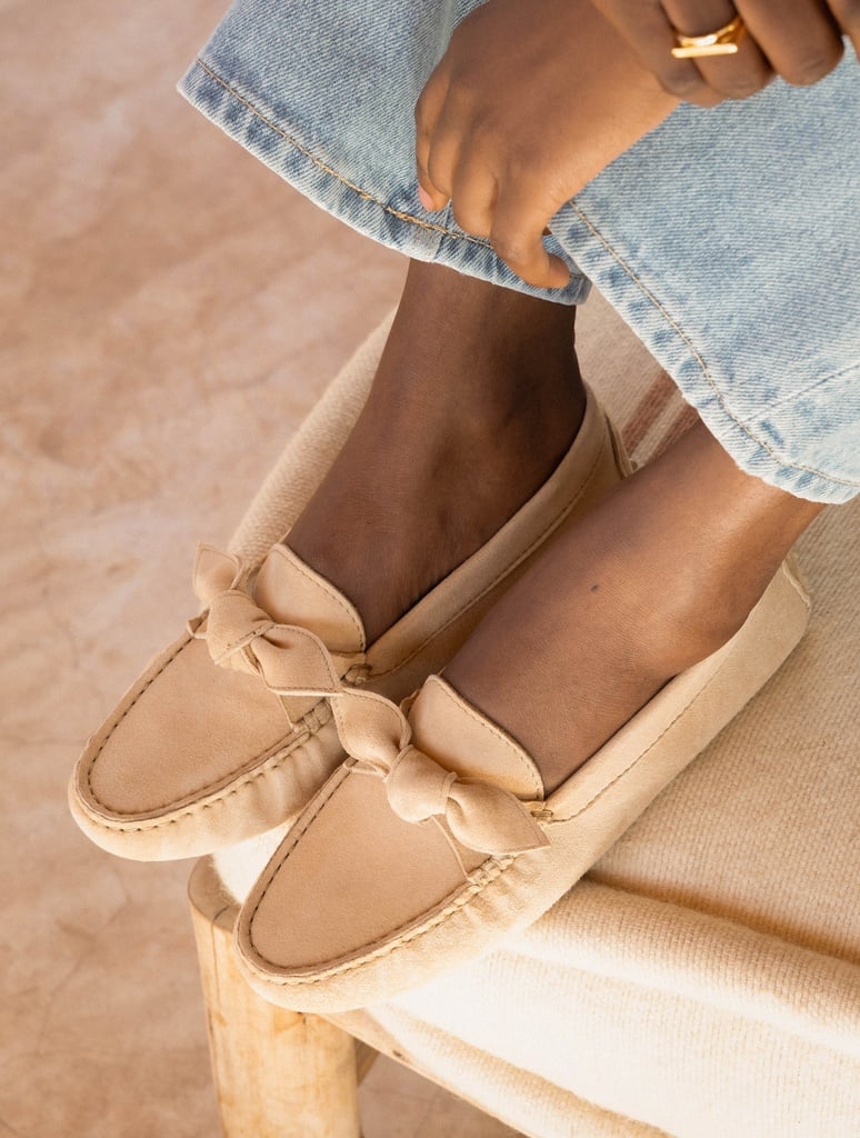 Mocassins Taline de Bobbies en daim beige avec nœud et semelle à picots, portés avec un jean clair