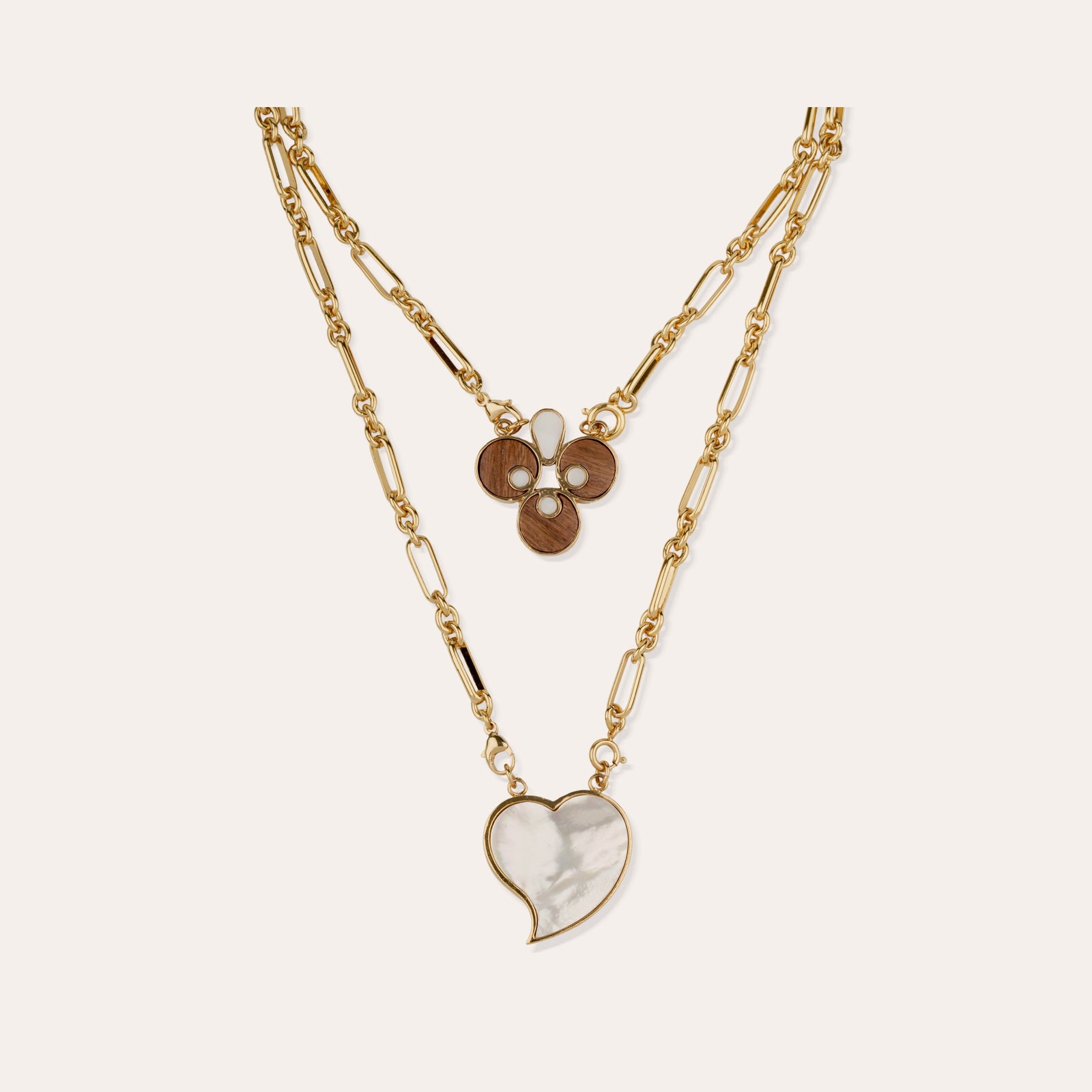 Collier scapulaire Mirage de Gas Bijoux, chaine figaro doree avec un coeur en nacre blanche et un motif de ronds en bois