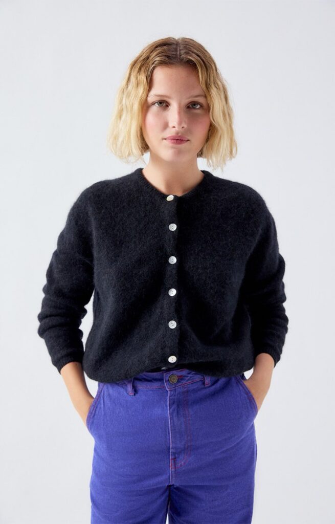 Gilet Vitow noir en maille alpaga d'American Vintage, coupe boule et boutons de nacre, porté sur un pantalon bleu électrique