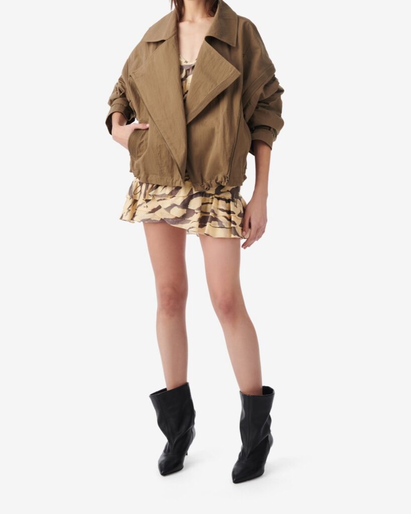Veste oversize Harper d'IRO en kaki, col large et bas blouson, portée sur une mini imprimee et des bottes noires