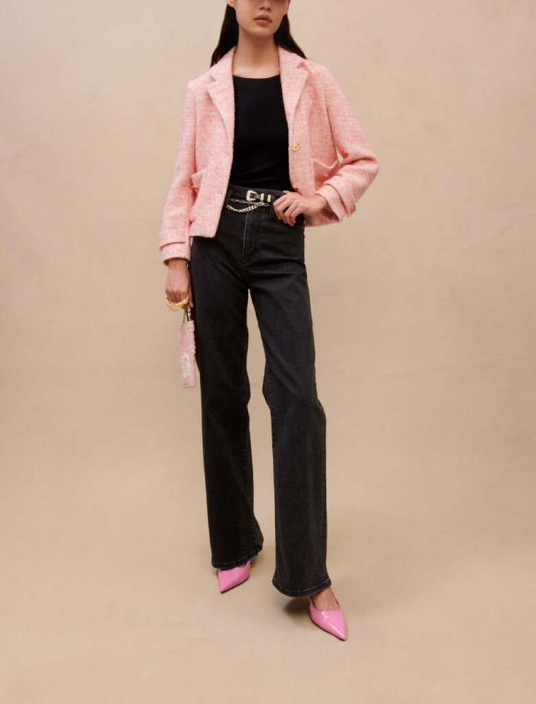 Veste de tailleur courte en effet tweed rose poudré Maje, portée sur un top noir et un jean large