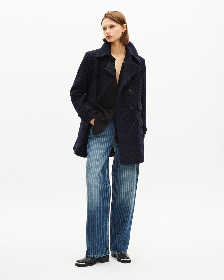 Manteau en laine bouclette bleu marine The Kooples, coupe droite et double boutonnage, porté sur chemise noire et jean large