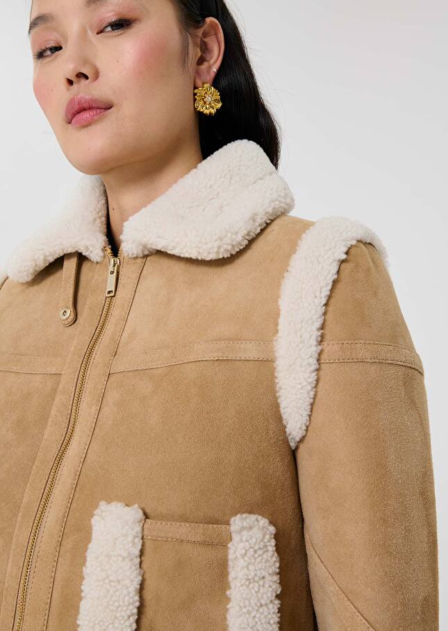 Court manteau Muse en peau lainée noisette de Tara Jarmon, bordé de mouton crème au col, aux emmanchures et aux poches, zip doré