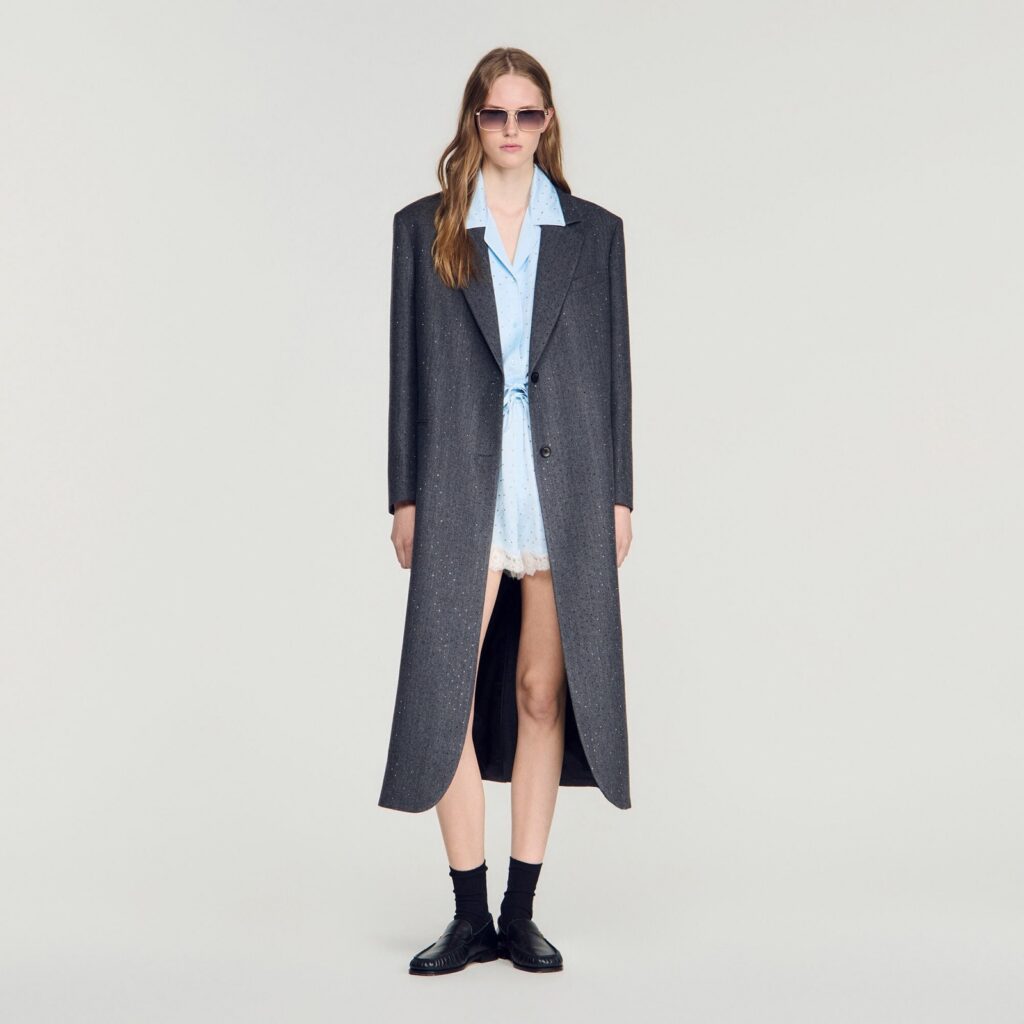 Long manteau de tailleur en laine grise ornée de strass, col cranté, porté ouvert sur une robe chemise bleu ciel - Sandro